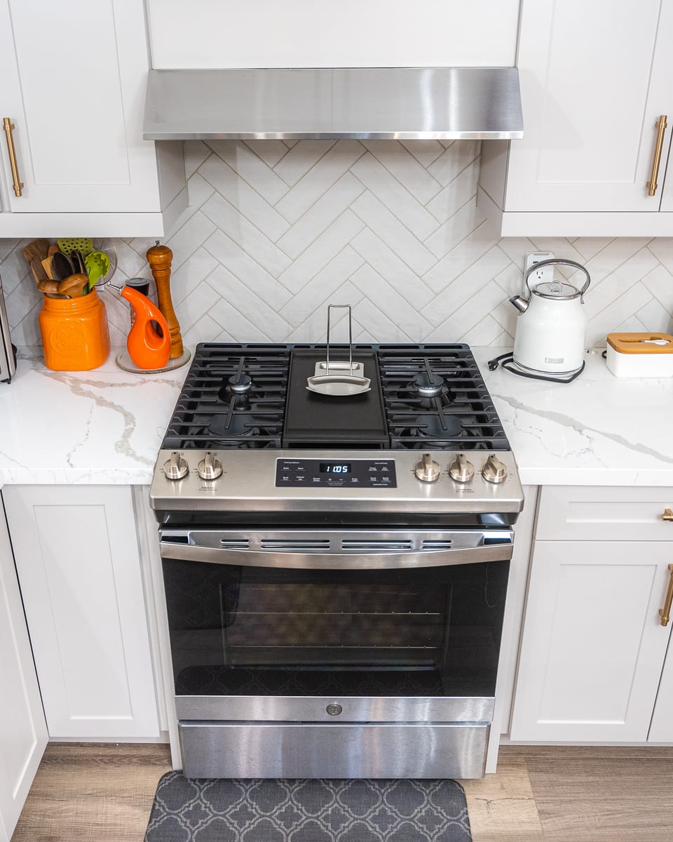 Chef's gas range with herringbone marble backsplash